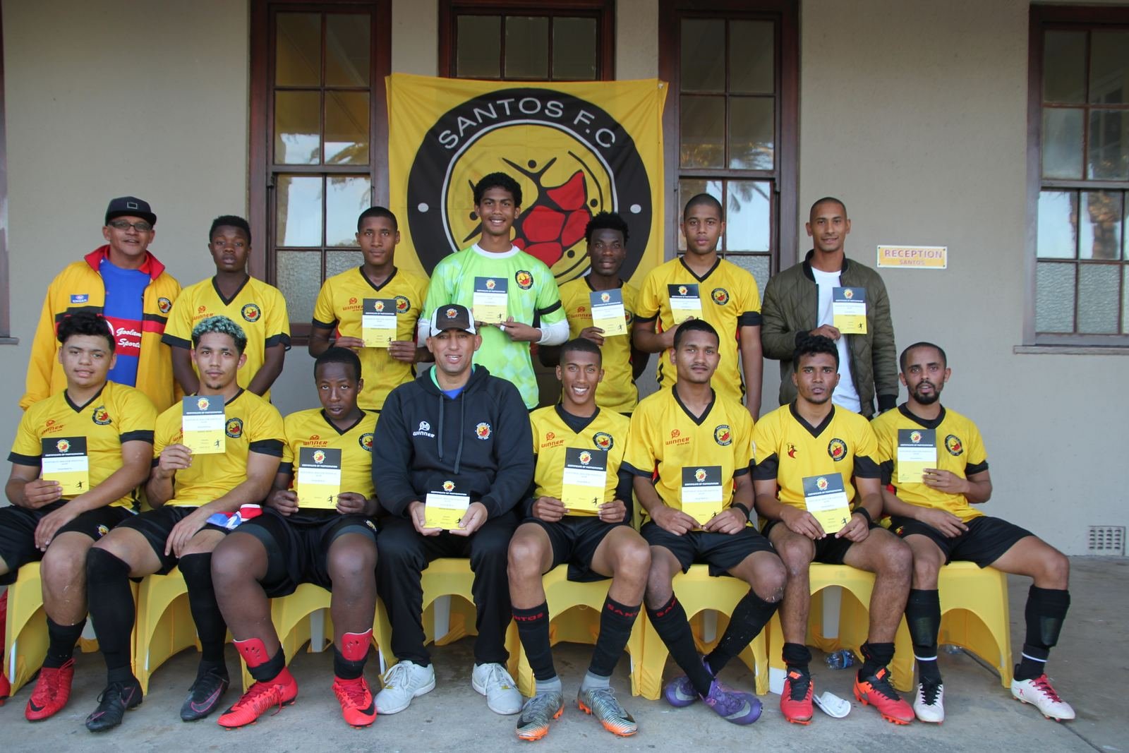 Santos FC Premier Team players and coaching staff with participation certificates at the clubhouse